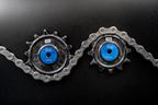 Bikone Forged Carbon Pulley Wheels, upper and lower pulleys threaded through a chain on a black background, road bike drivetrain components