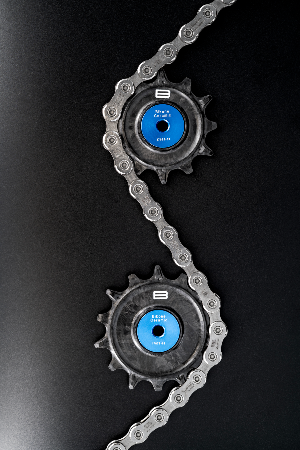 Bikone Forged Carbon Pulley Wheels, upper and lower pulleys with a chain routed between them, road bike drivetrain components